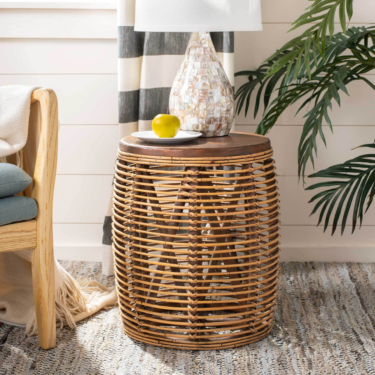 Honey-brown woven stool works as a side table for a lamp and a small tray