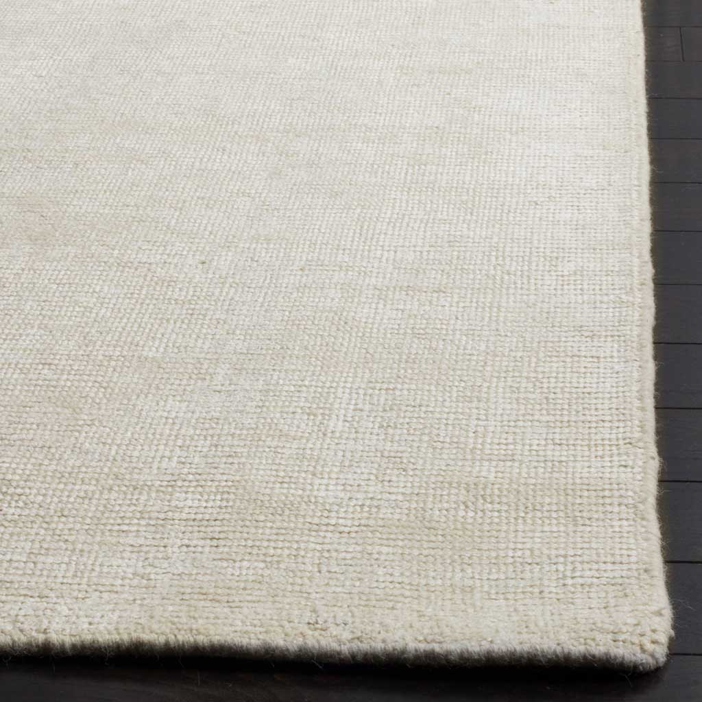 Low ivory pile and a softly finished edge showcase the rug's quiet texture