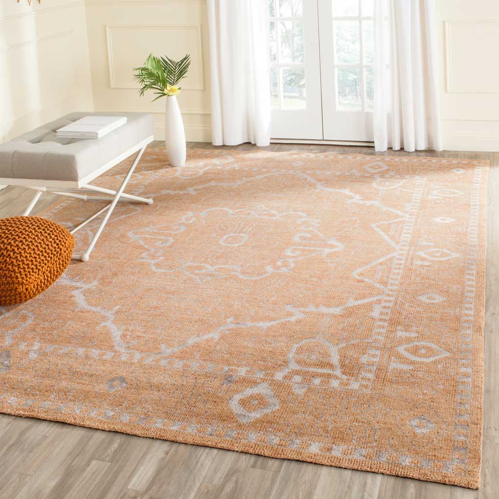 Faded silver flourishes soften the warm peach hue of this traditional area rug