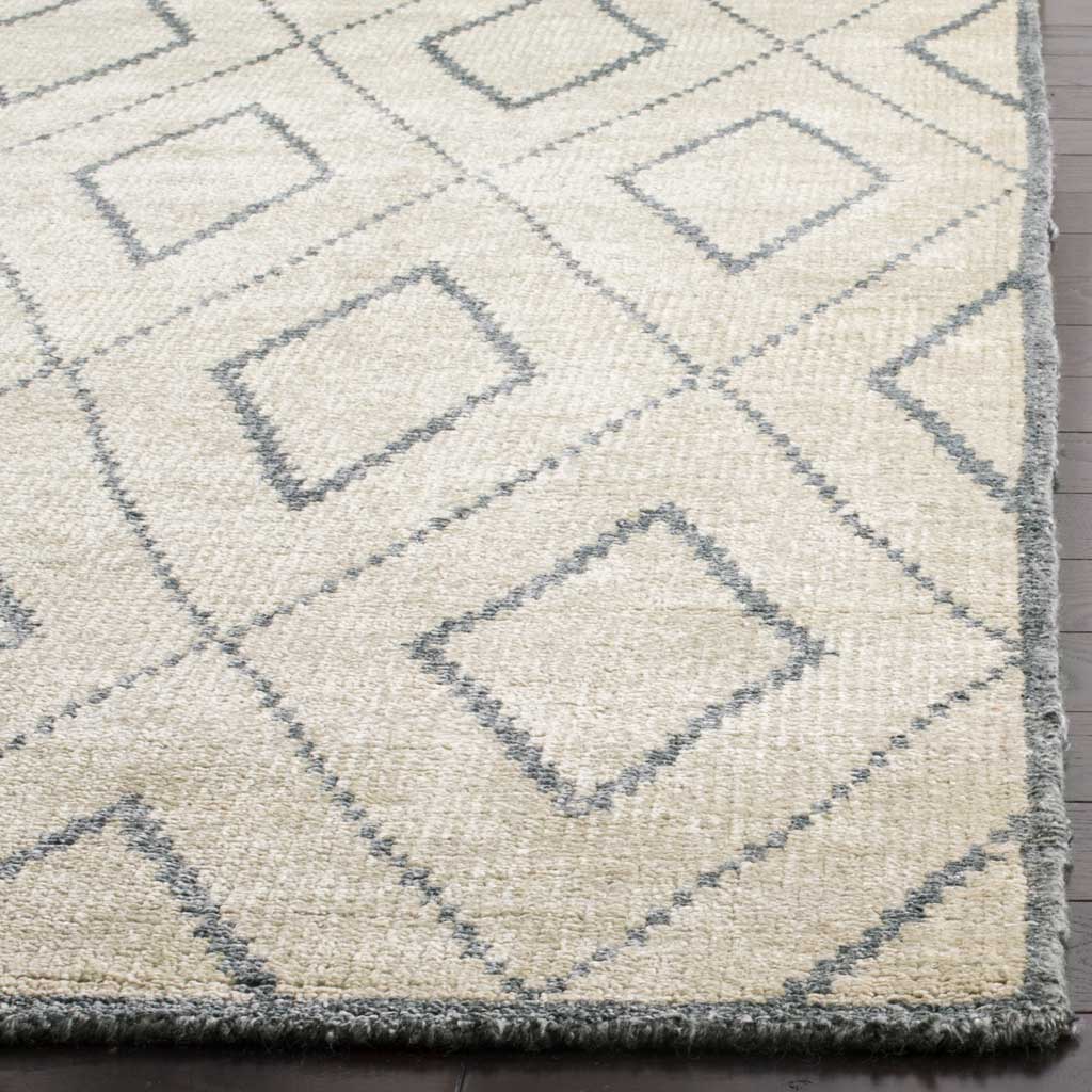 Raised ivory texture and delicate gray diamond lines bring depth to the rug's edge