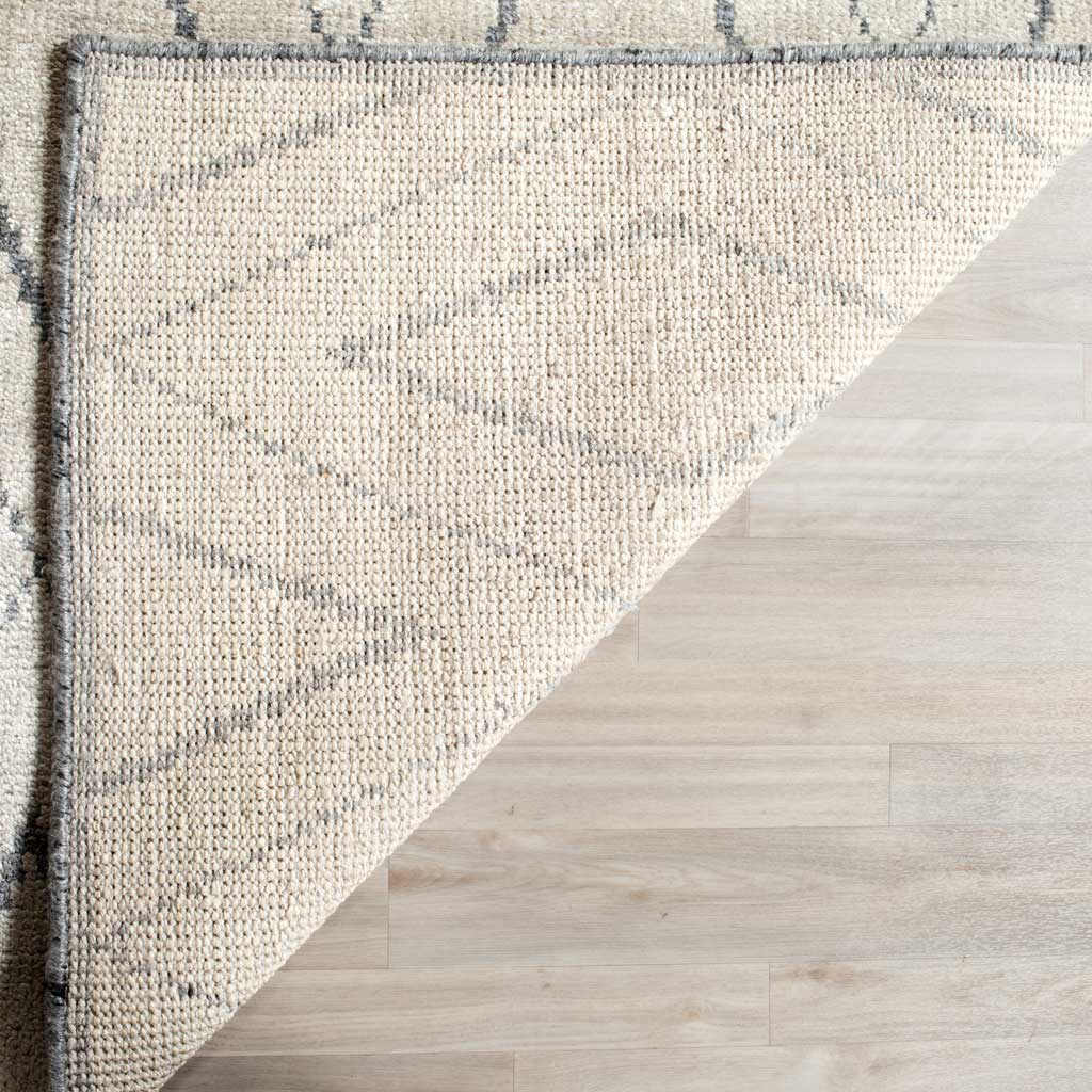Folded corner reveals the rug's woven underside and gray-bound edge