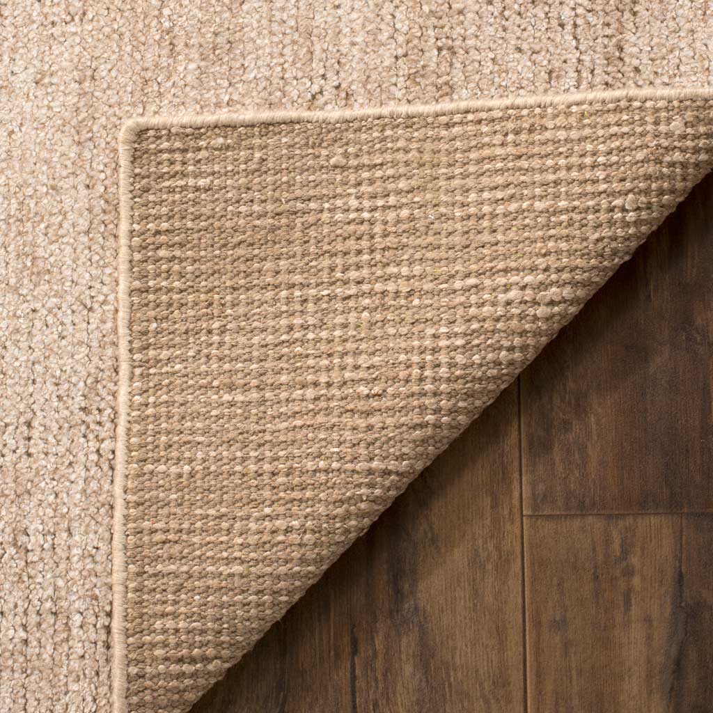 Woven backing and bound edges complete this soft beige rug