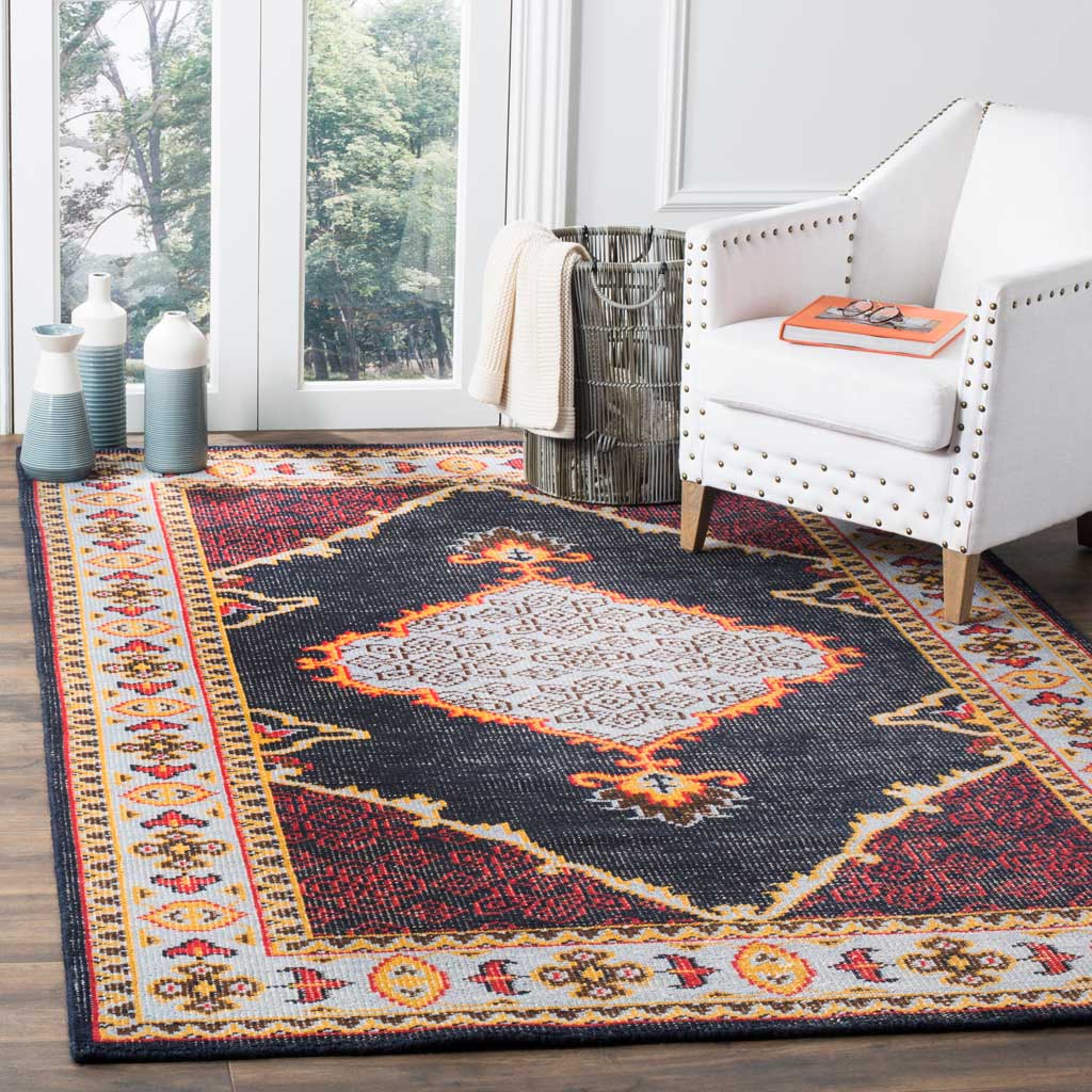 Navy rug with a pale medallion and vivid red and gold accents beneath a white chair