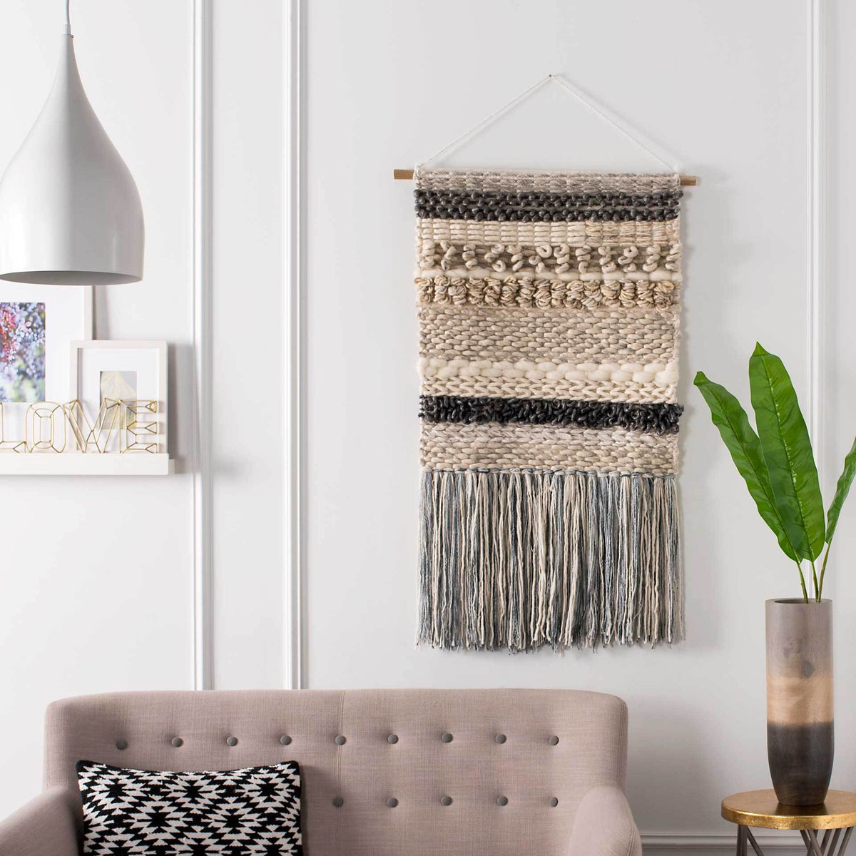 Cream and charcoal textured bands give this fringed wall hanging a relaxed, layered look.