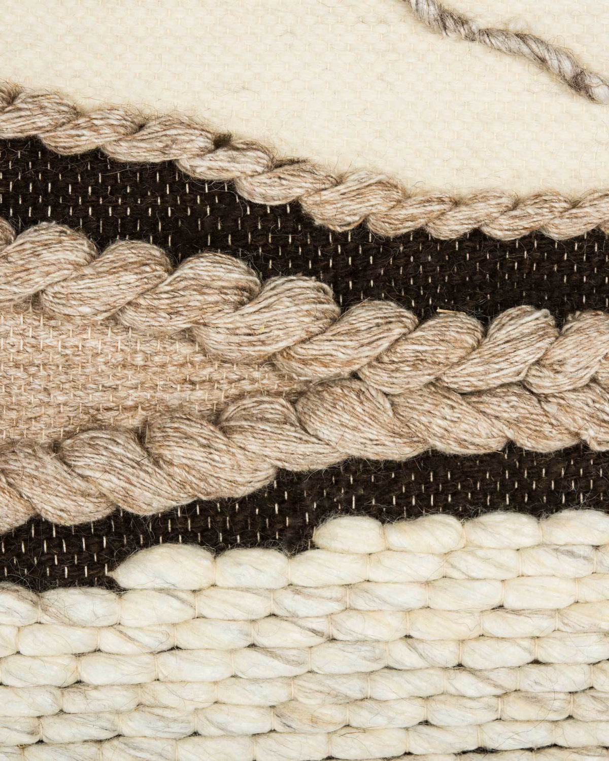Chunky beige braids trace dark brown bands across the creamy wool-and-bamboo weave.