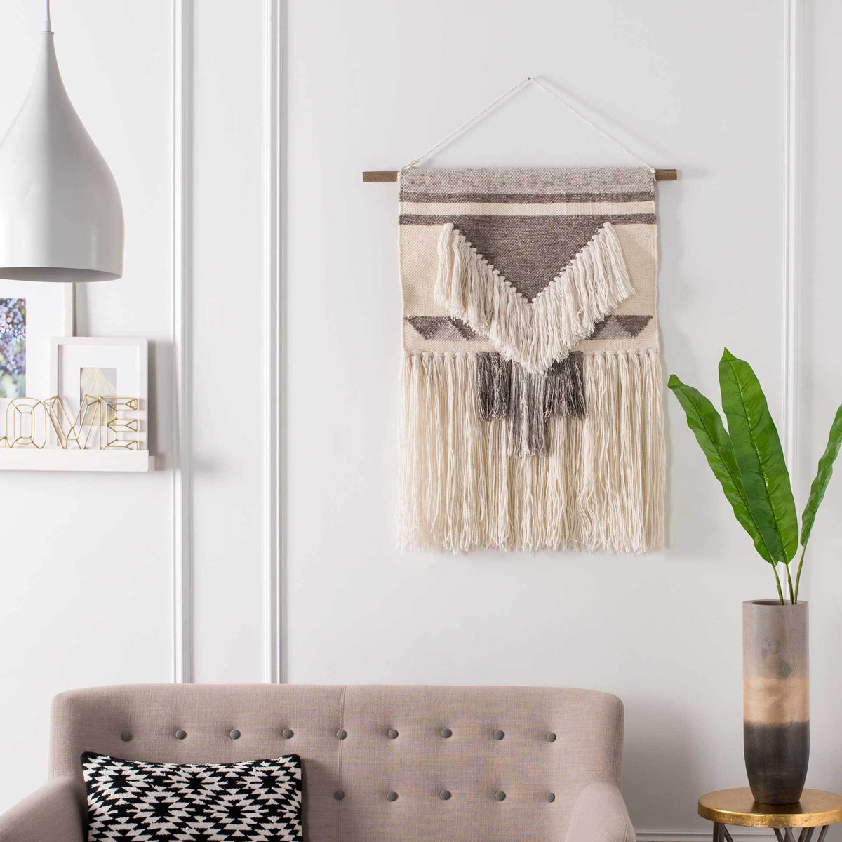 Brown geometric bands and ivory V-shaped fringe lend sculptural texture to this hanging wall art.