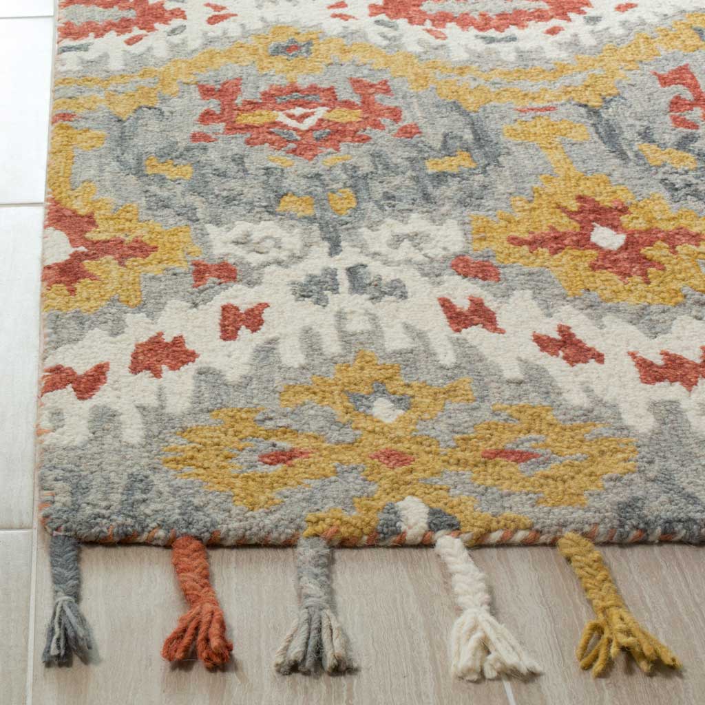 Textured wool pile and warm gold and rust motifs meet a bound edge finished with colorful tassels
