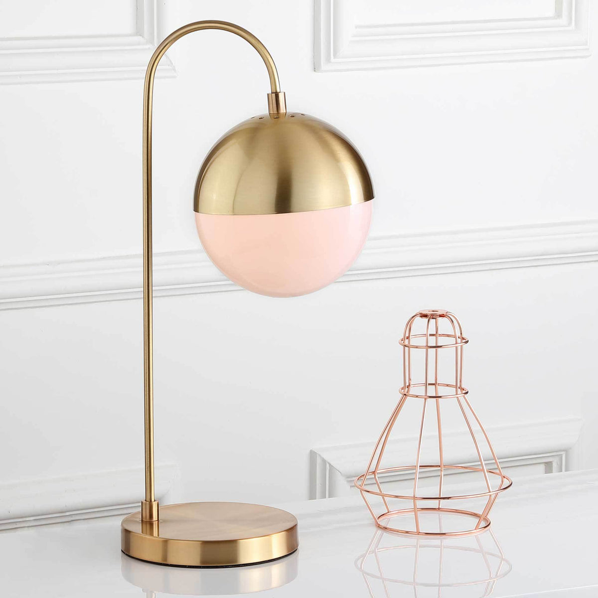 A softly glowing globe and brass-finish dome bring warm light to this arched table lamp.