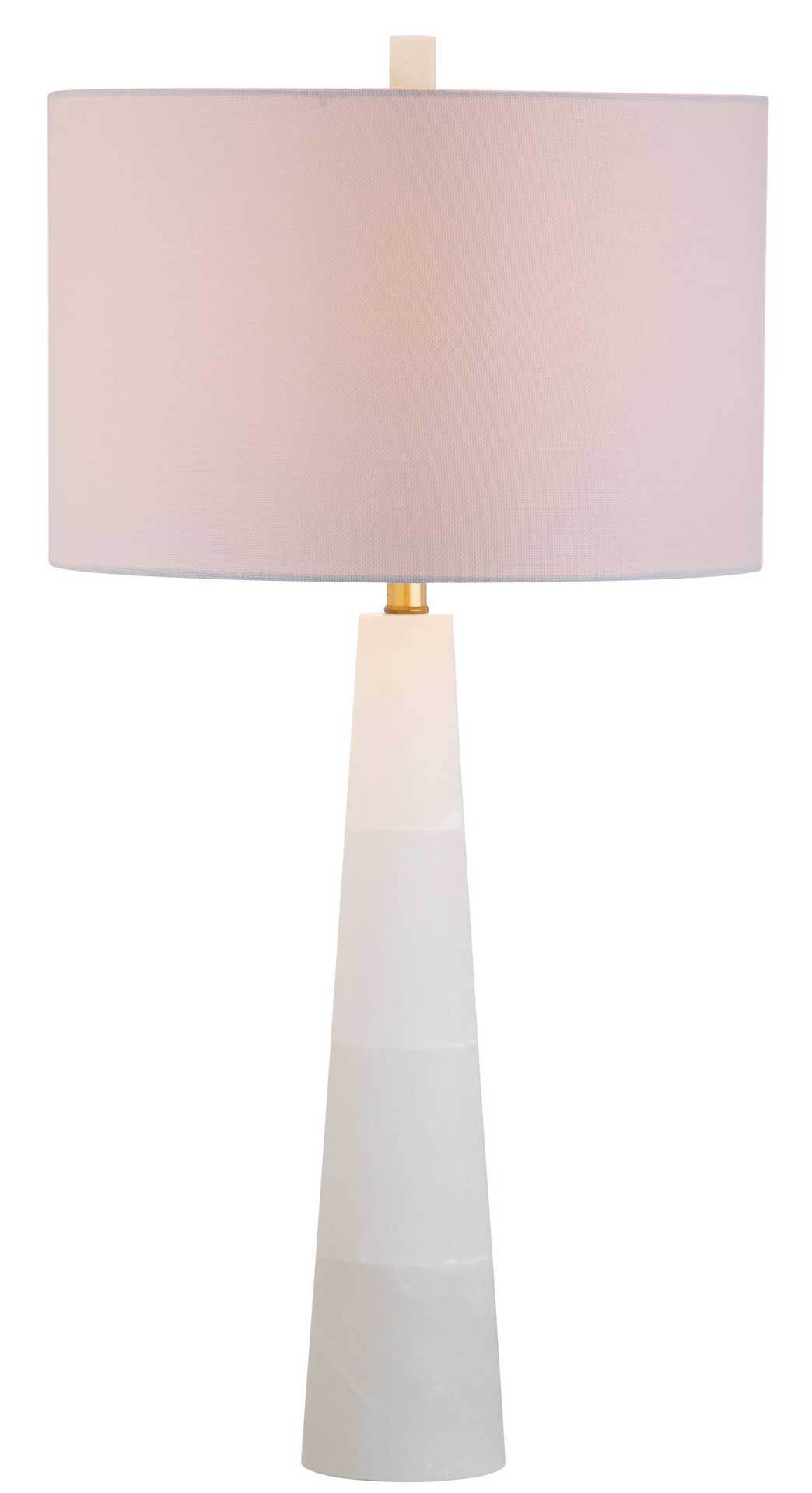 A softly glowing drum shade casts warm light above a tapered alabaster base with gold-tone accents.