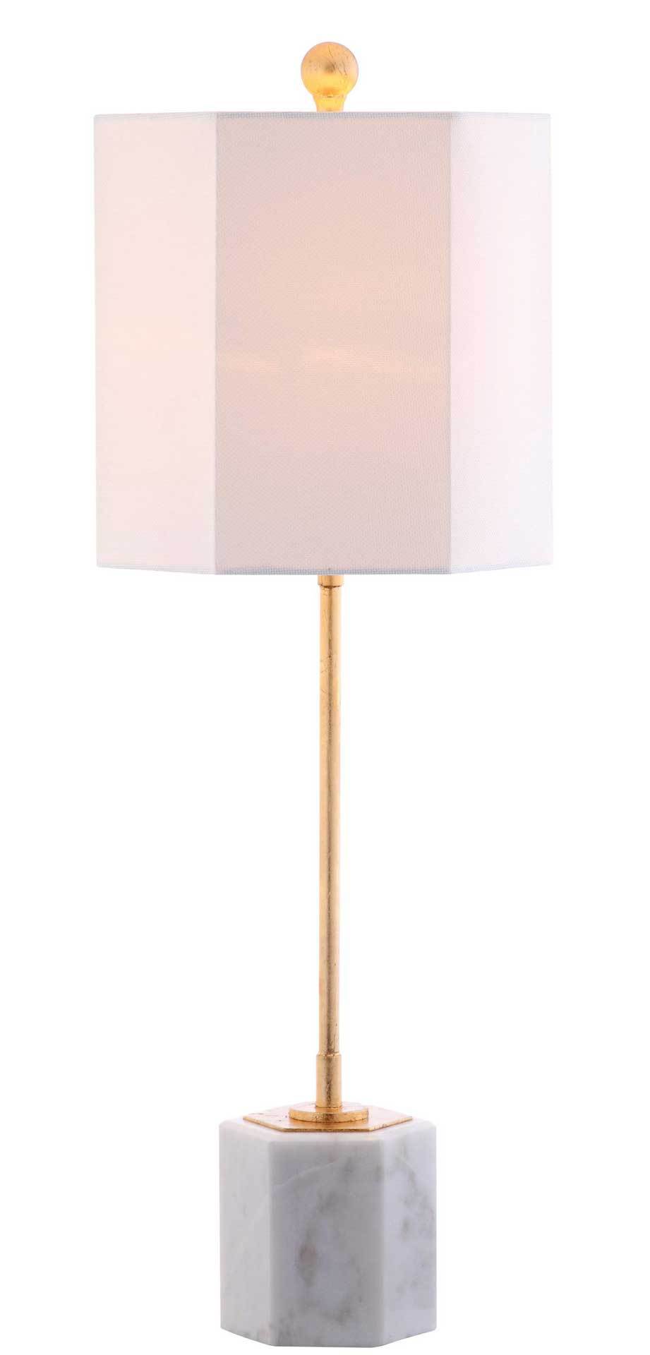 A warmly lit white shade glows above a slender gold stem and white marble cube base