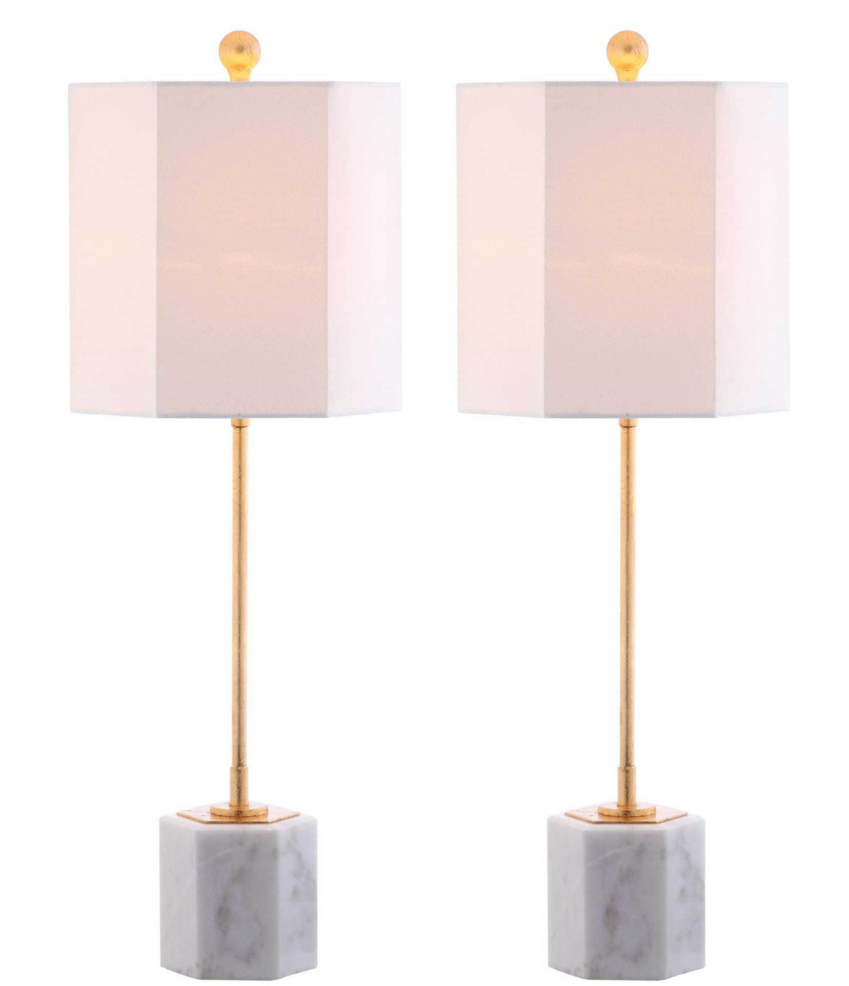 Warm light shines through two white fabric shades above gold stems and white marble cube bases
