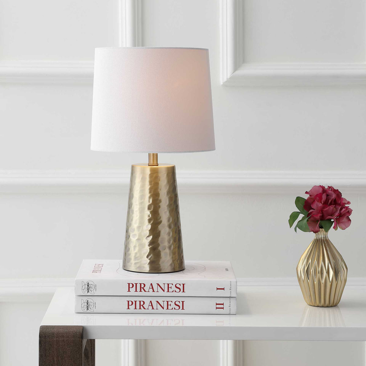Soft light fills a white fabric shade above a hammered gold-tone metal base.