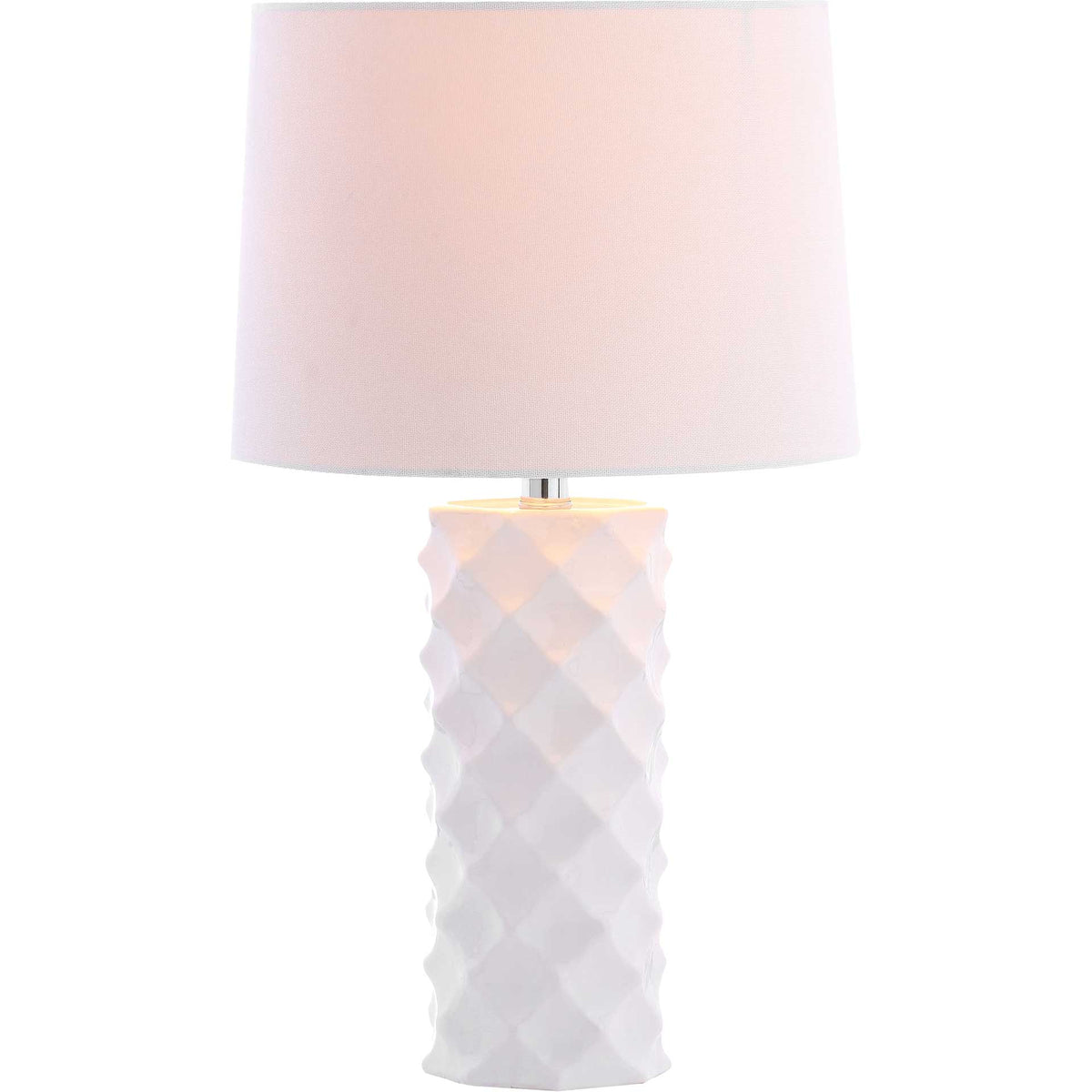 Soft light warms the white fabric shade above a sculpted ceramic base