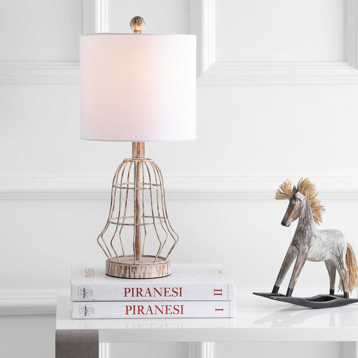 A softly glowing drum shade tops the antique brown metal base for a warm tabletop accent.