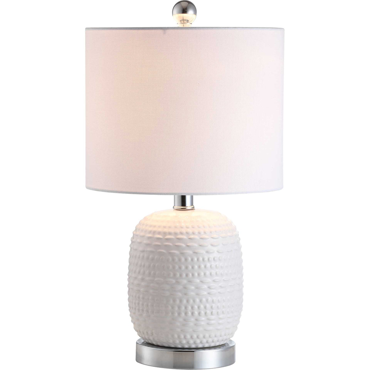 Soft light glows through the white fabric shade above a textured ceramic base and chrome foot