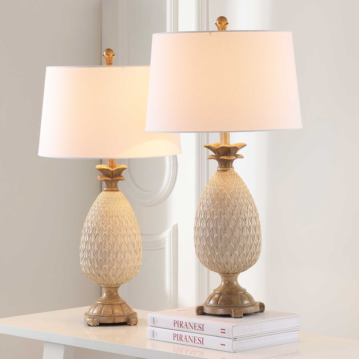 A matching pair of textured cream lamps brings a warm glow to the room through white fabric shades
