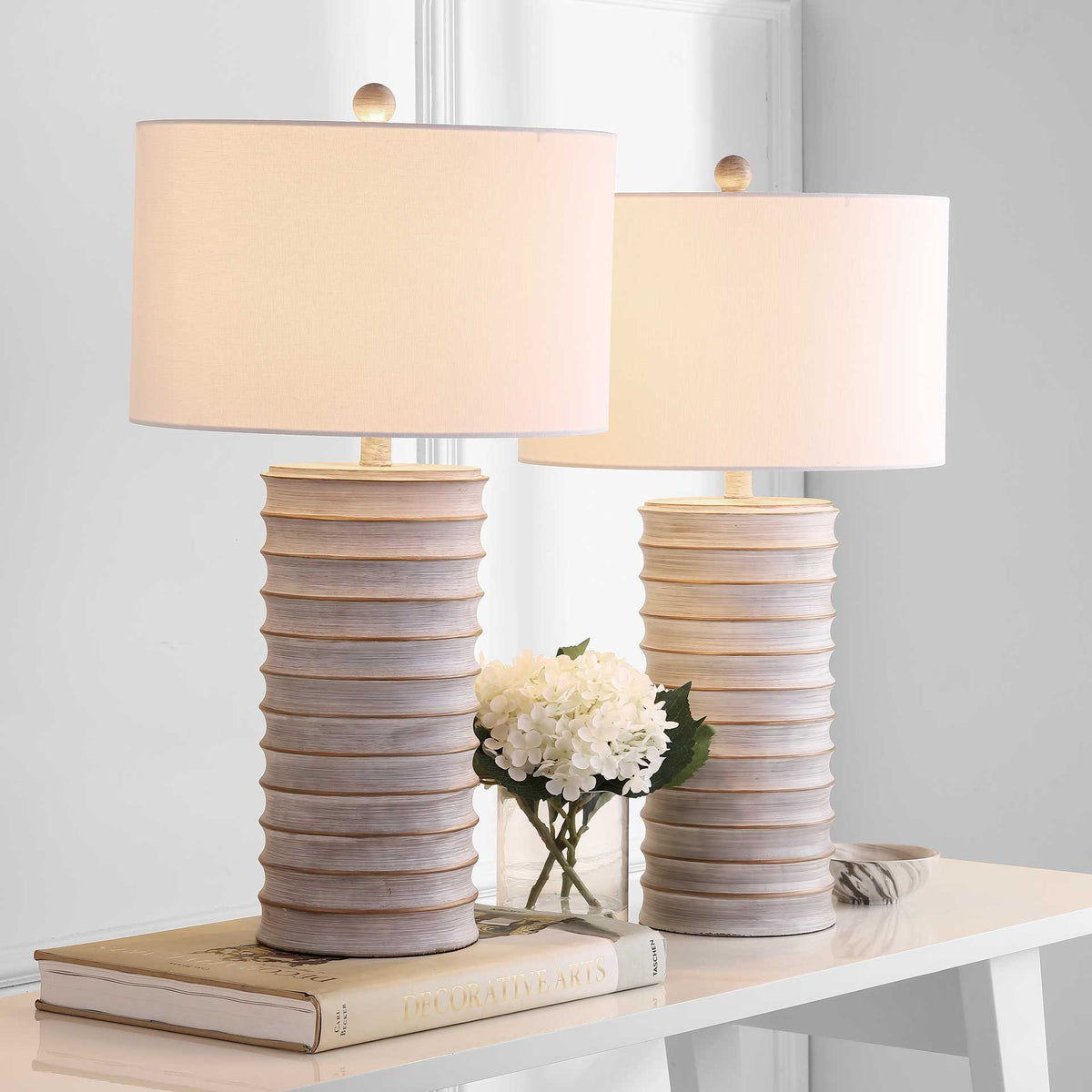 Two glowing white drum shades brighten matching ribbed gray table lamps