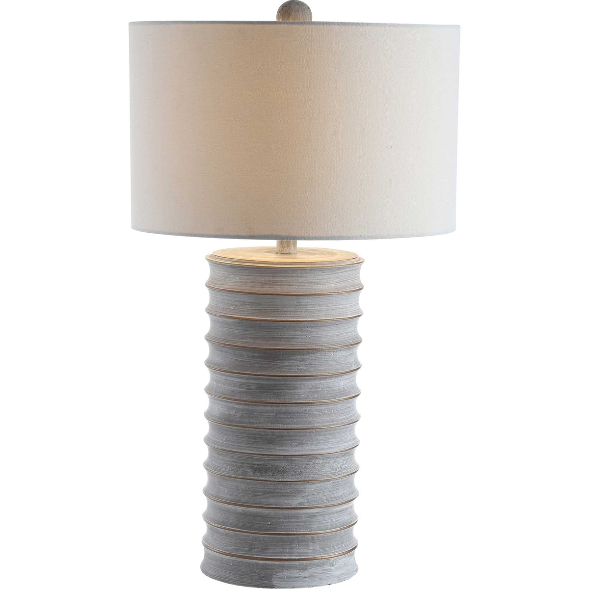 Warm light glows through a white drum shade above a ribbed gray base