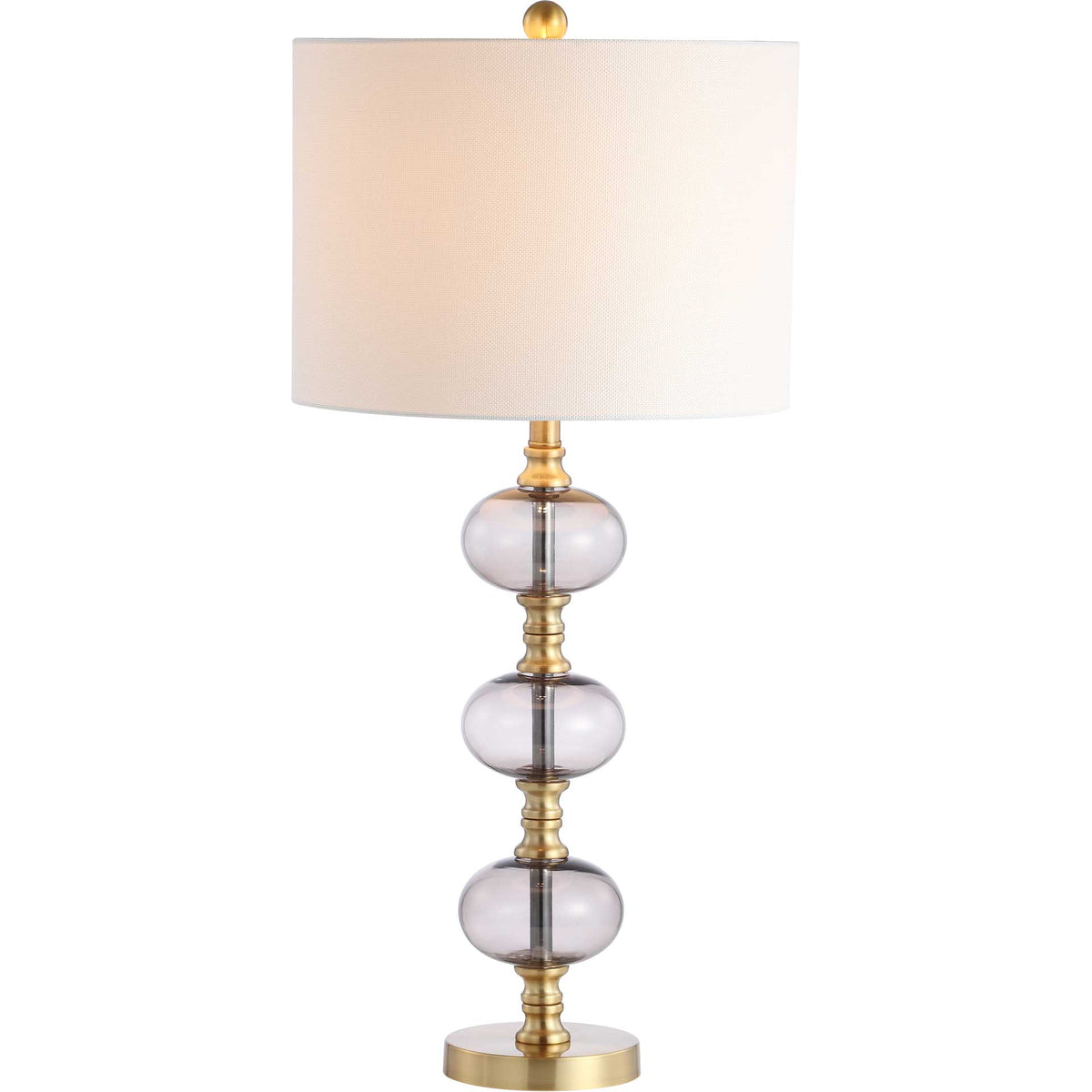 Warm light glows through the white drum shade above three smoky glass orbs and brass accents.