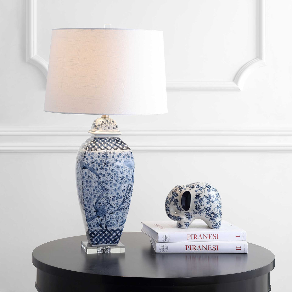 Soft light warms the white shade above a blue-and-white ceramic body with floral detailing
