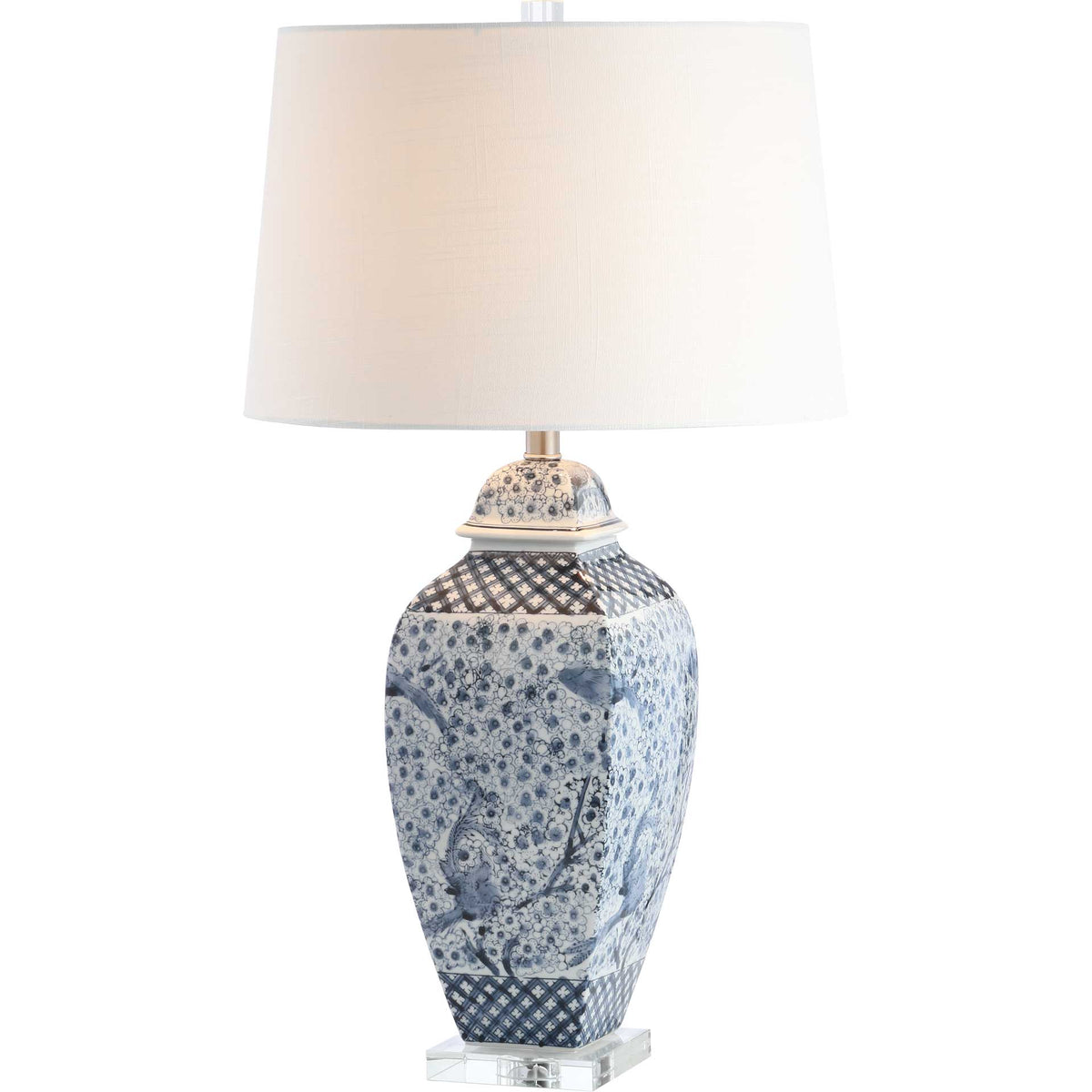 A warm glow highlights the white fabric shade and detailed blue-and-white ceramic body