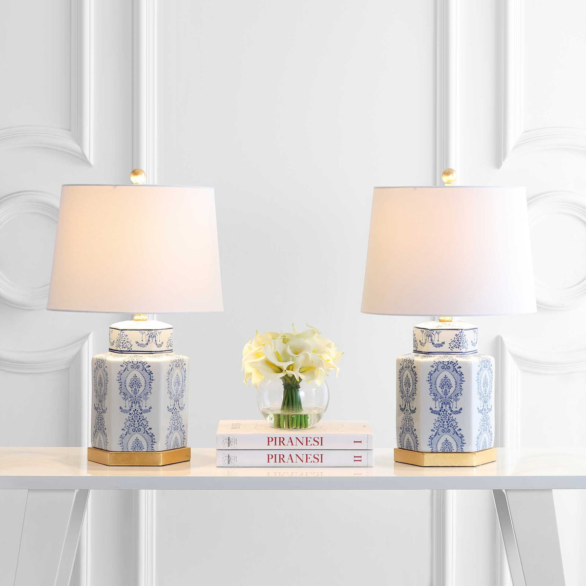 Two patterned ceramic lamps cast a warm glow through tapered white shades above gold bases