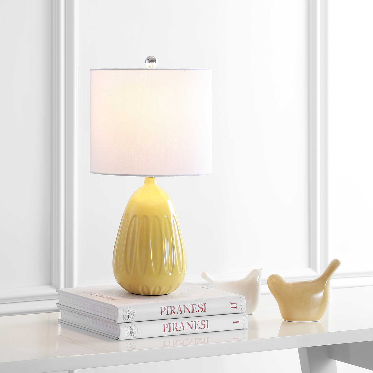 Soft illumination from a white shade pairs with a glossy yellow base for inviting ambient light.