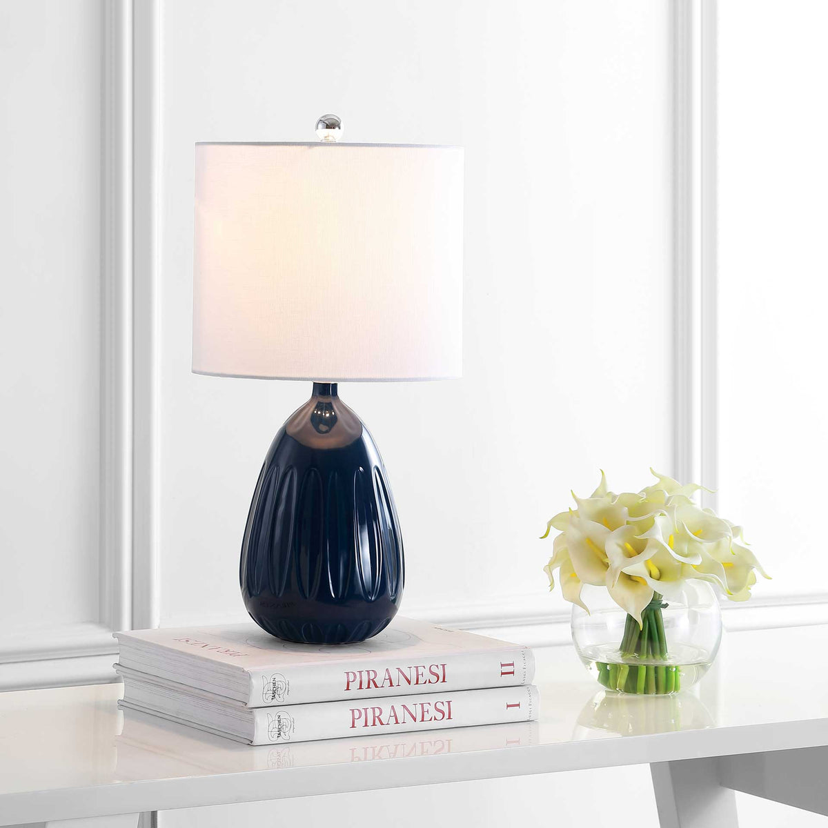 A softly glowing shade complements the glossy navy base and its sculpted detailing.