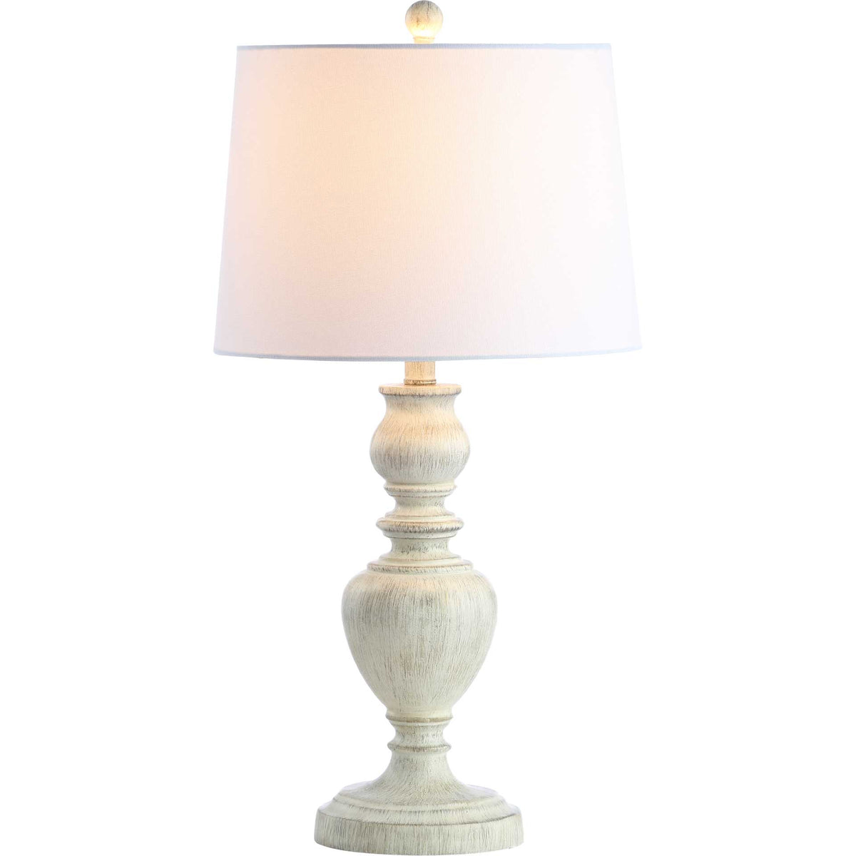 A warm glow shines through the white shade above the textured, whitewashed base.