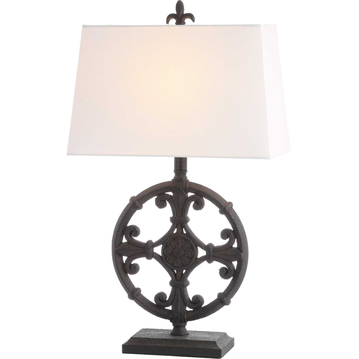 Warm light glows through the white shade above an ornate black scrollwork base