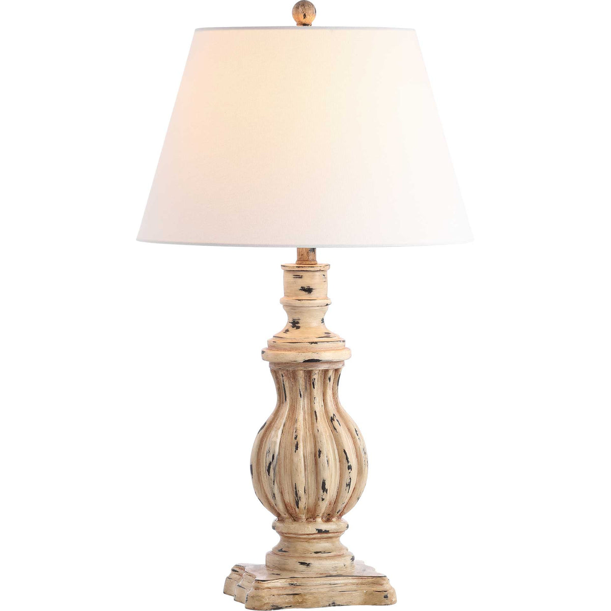 Warm light glows through a white shade above a weathered brown lamp base.