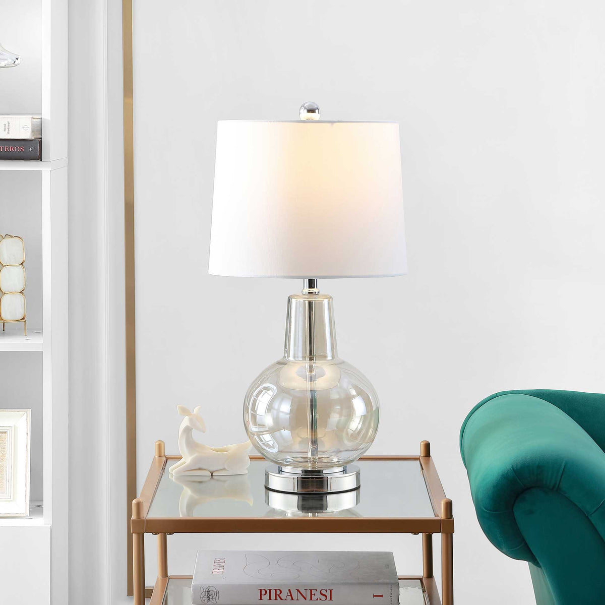 Warm light shines through the white shade above a clear glass globe and chrome-tone foot.