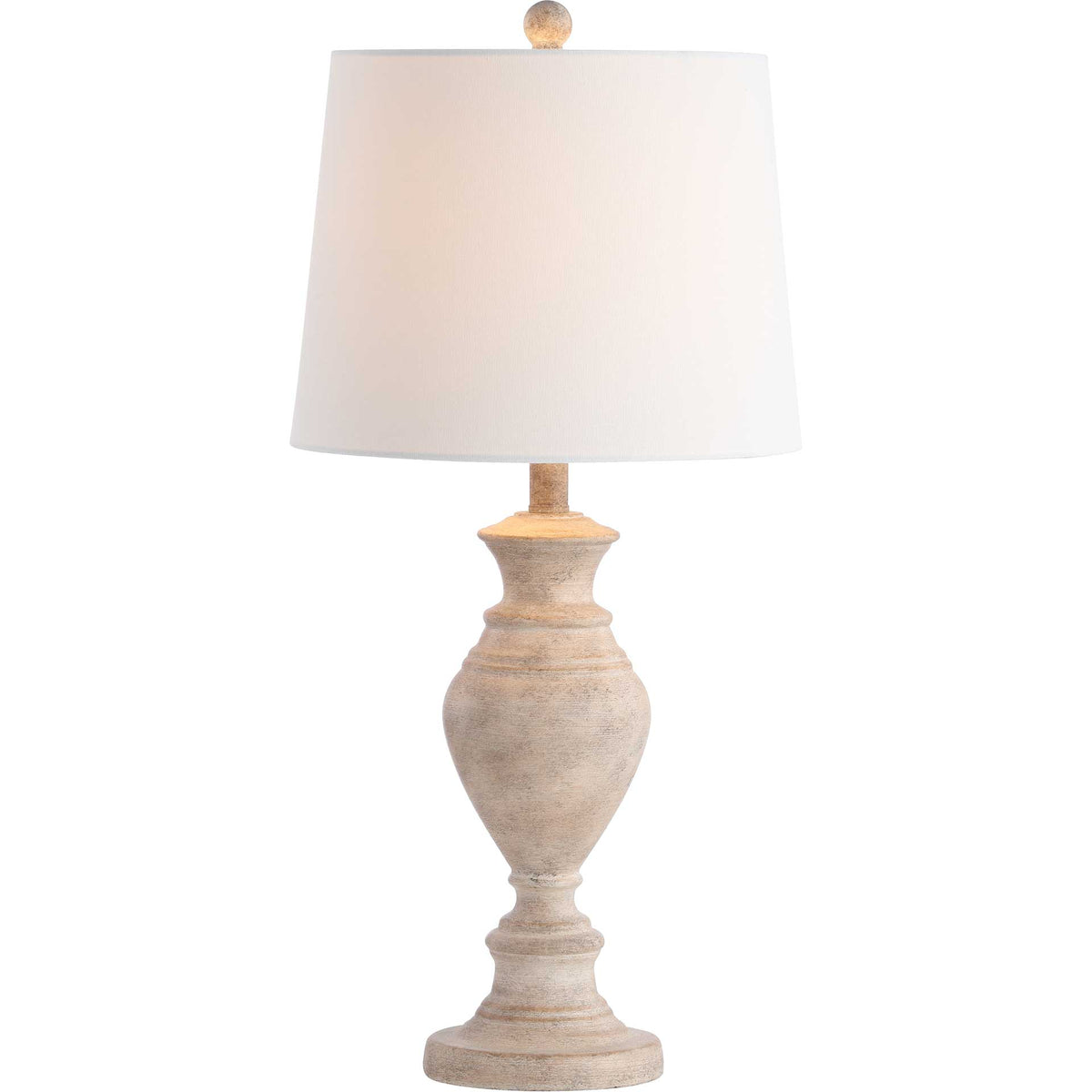 Warm light glows through a white shade above the sculpted, light brown base.