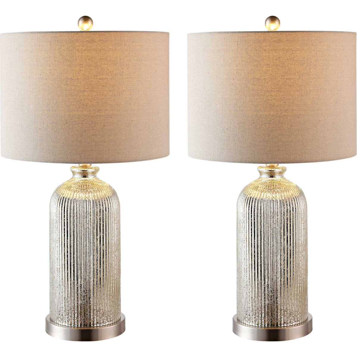 A pair of lamps glows warmly through textured shades above shimmering glass bases.