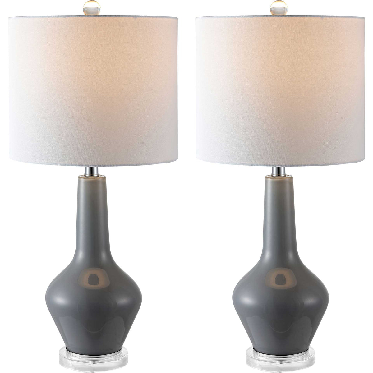 A pair of gray glass lamps radiates warm light through textured white drum shades