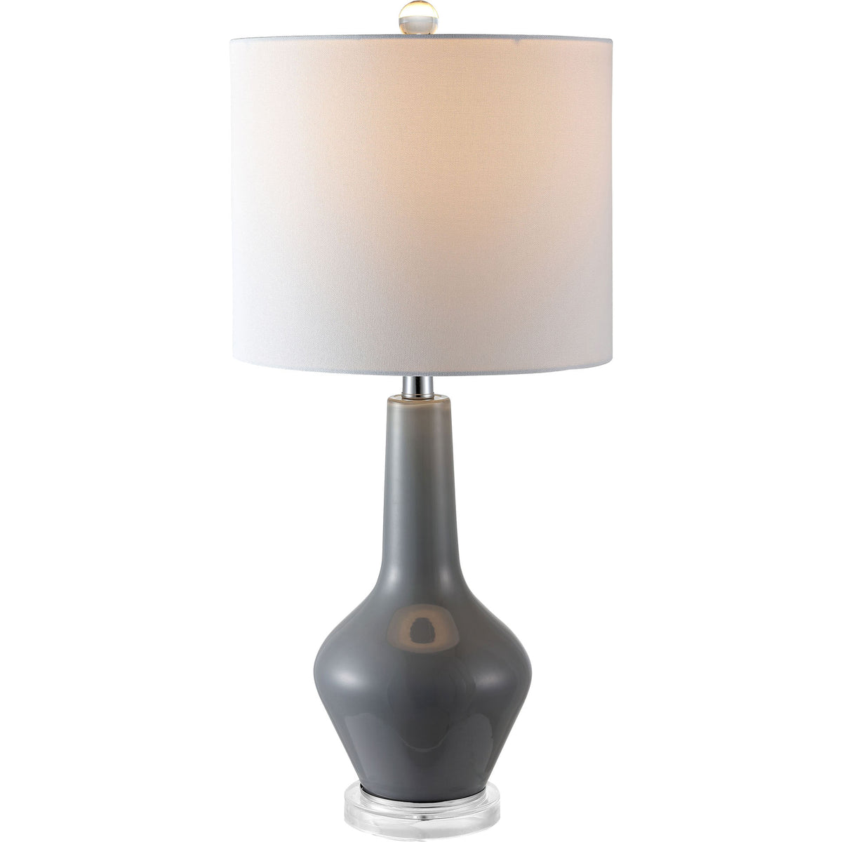 Gray glass lamp with a warm glowing drum shade and sleek, sculpted base