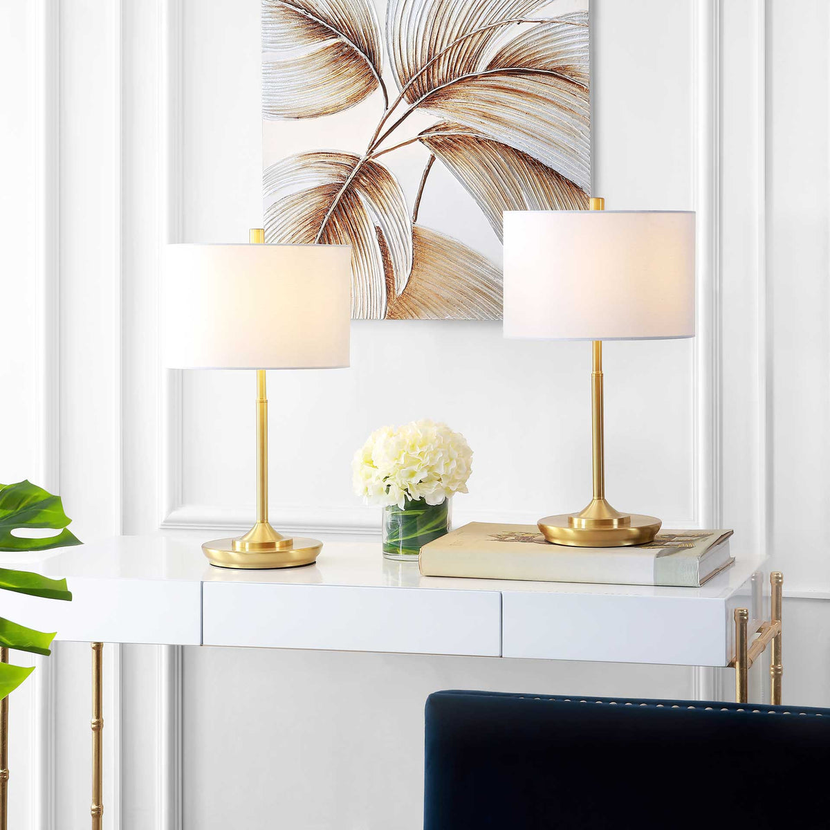 Two brass-gold table lamps cast a warm glow through their white drum shades.