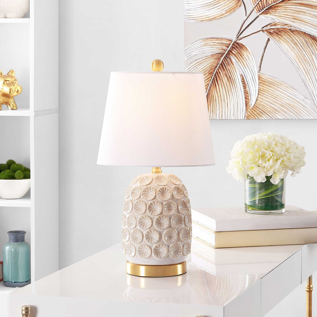 Warm light illuminates the white shade over a floral ceramic base and gold-tone details