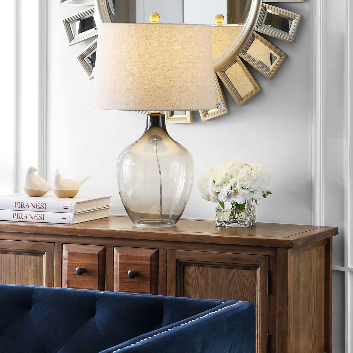A softly glowing shade and smoky glass base bring inviting warmth to the living space.