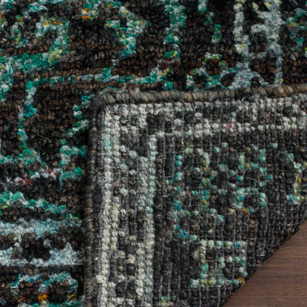 A folded corner reveals the woven underside beneath the rug's patterned aqua and chocolate surface.