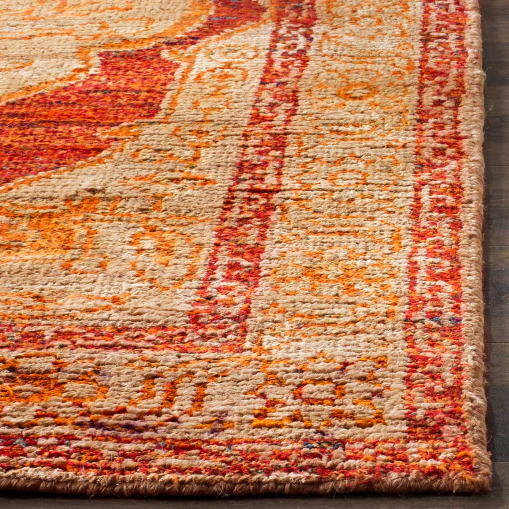 Textured red-orange and beige floral details meet at a neatly finished rug corner