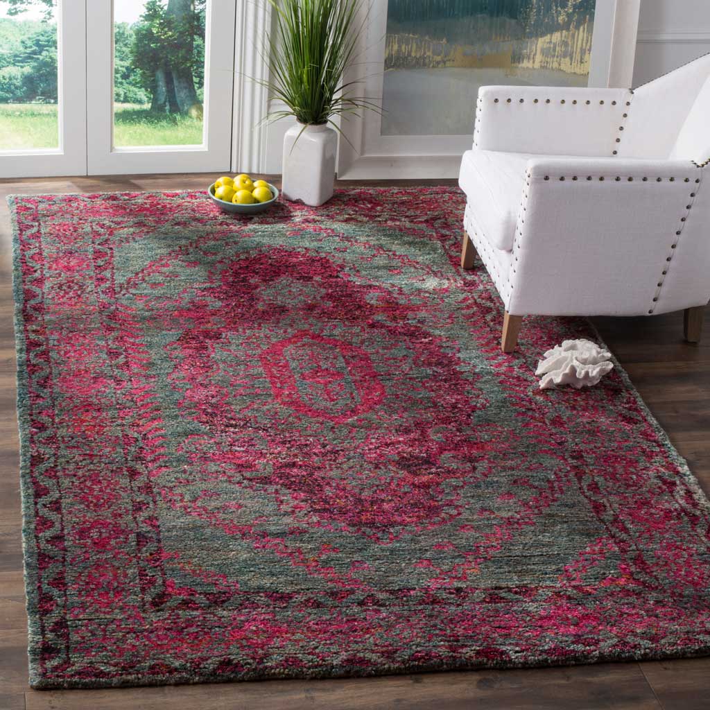 Slate blue and fuchsia medallion rug brightens a sunlit room beside a white armchair