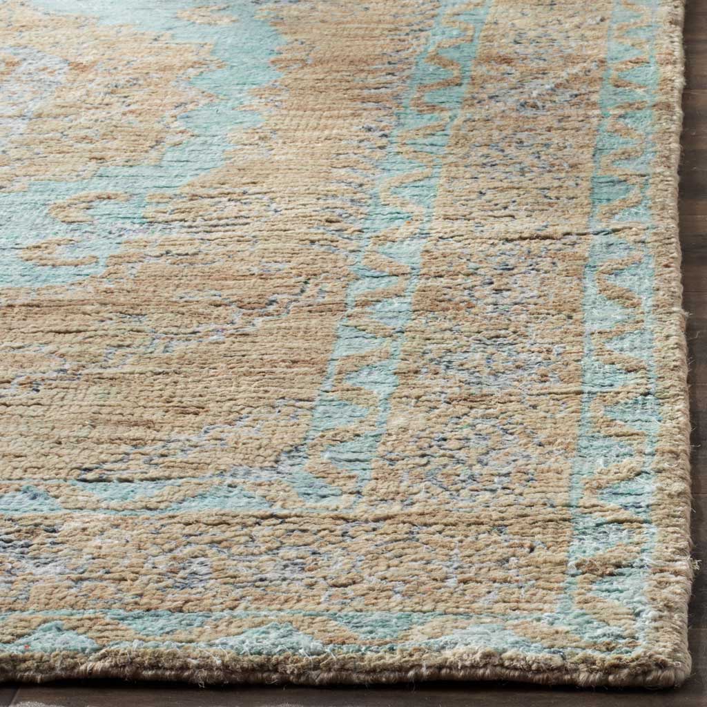 Textured seafoam motifs and warm beige fibers meet at a neatly finished rug corner