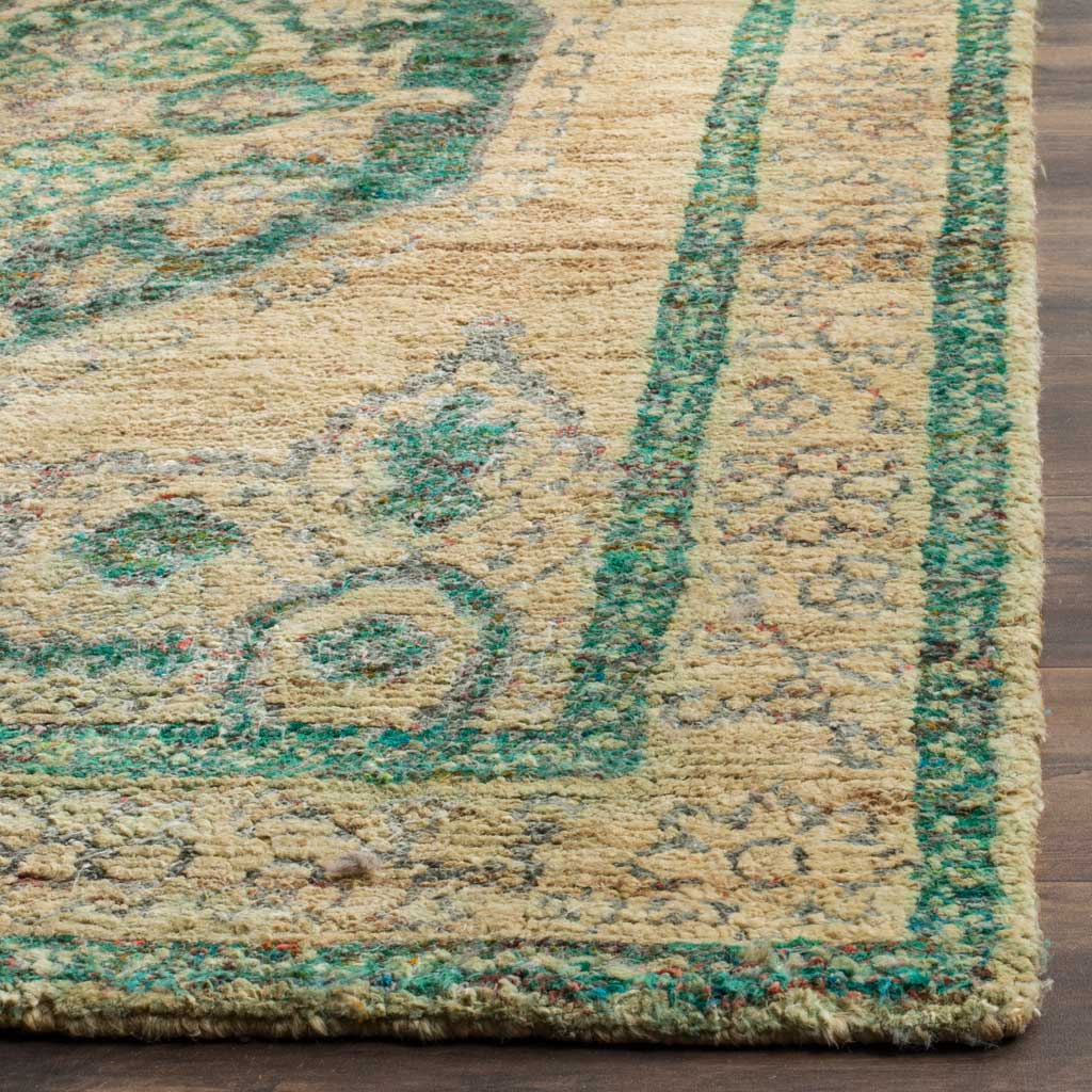 Emerald border detailing and muted floral motifs frame a thick, textured rug edge