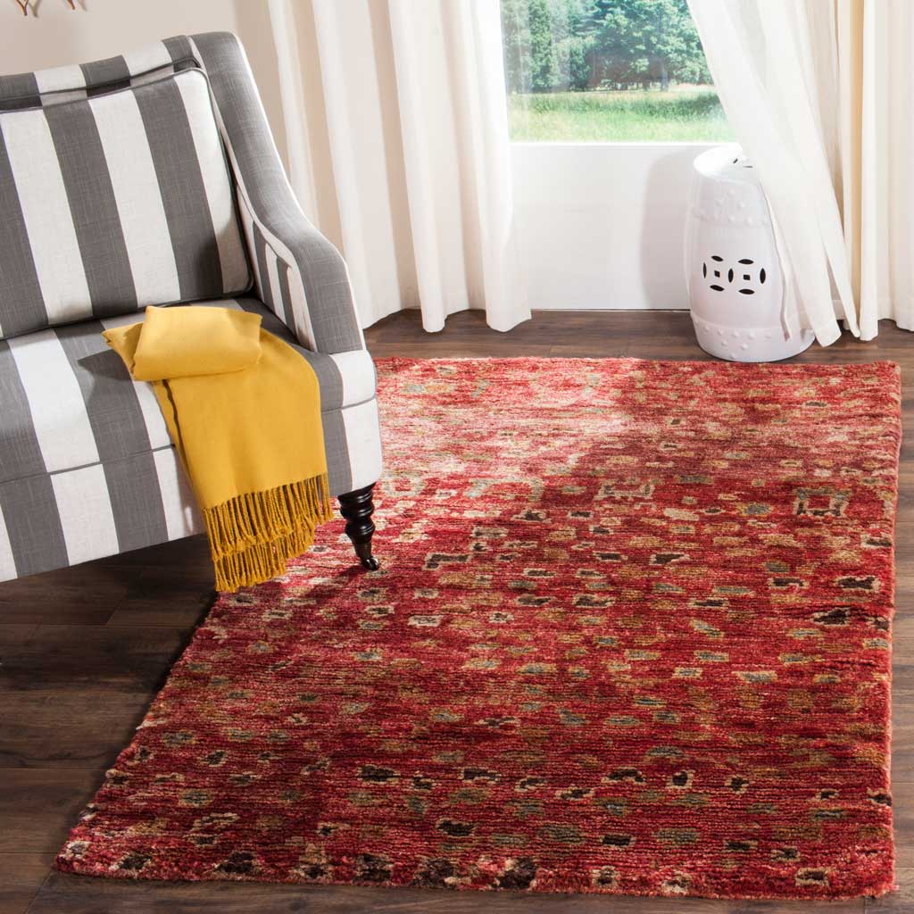 A richly patterned red area rug adds warmth and color to a cozy seating area