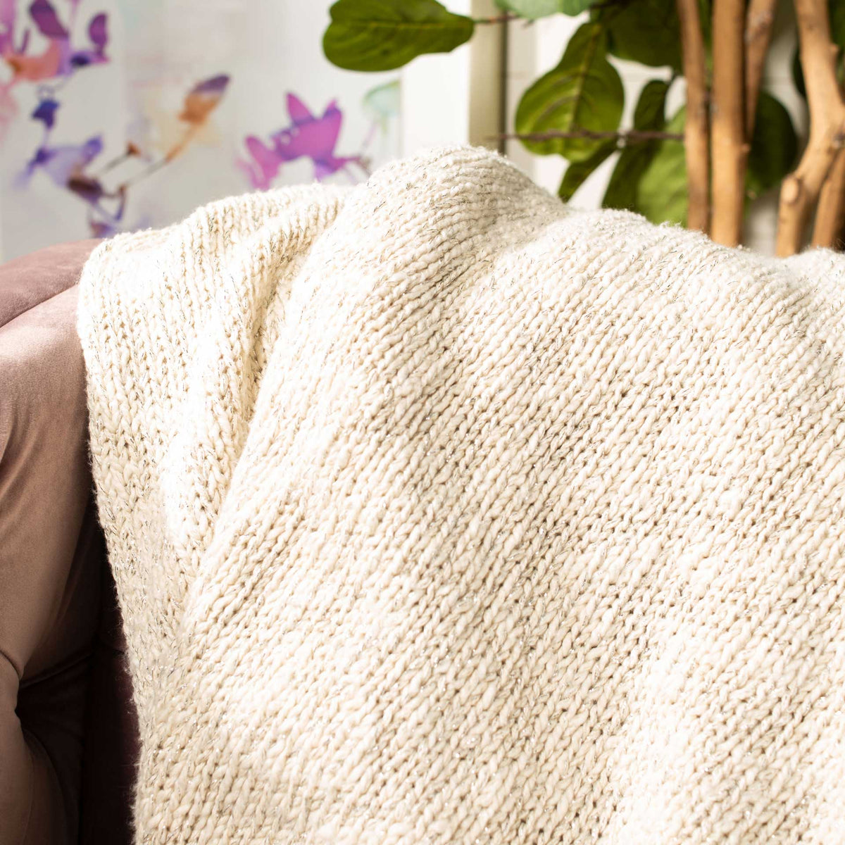 Soft natural yarn gives the throw a plush, inviting texture with touches of silver sparkle