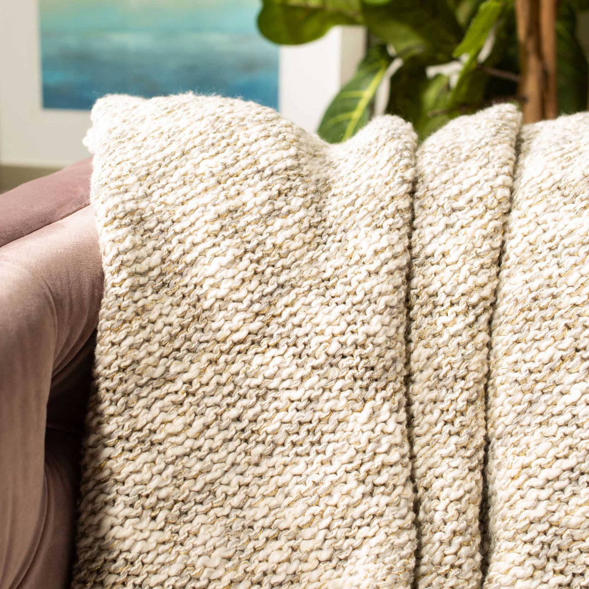 Nubby gray-and-cream stitches lend the throw cozy texture and a touch of gold sparkle