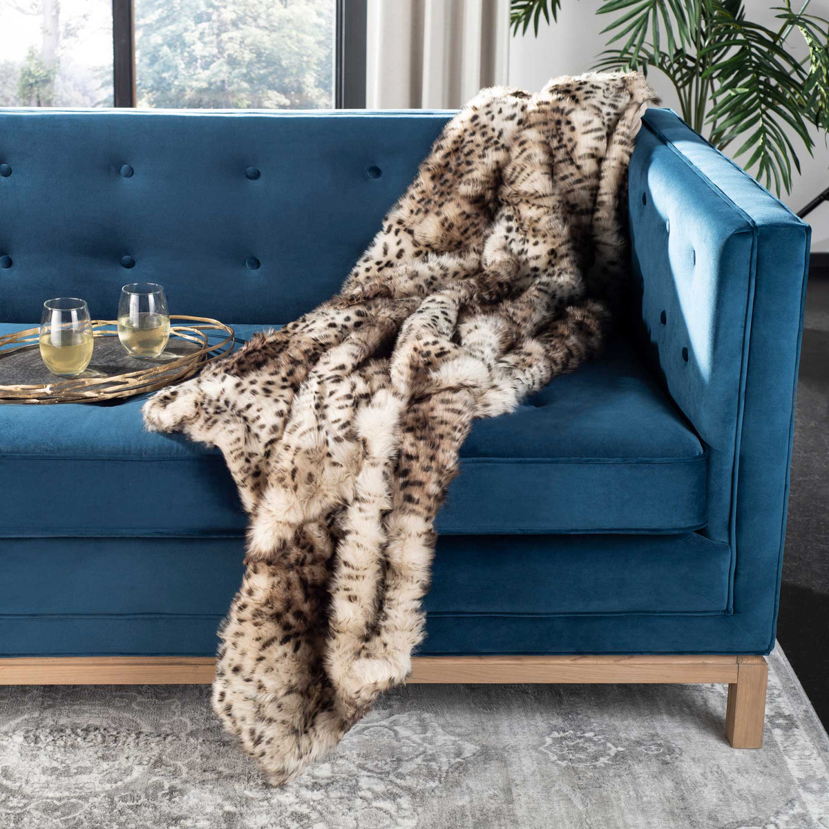 Spotted faux fur adds warmth and pattern to a blue sofa.