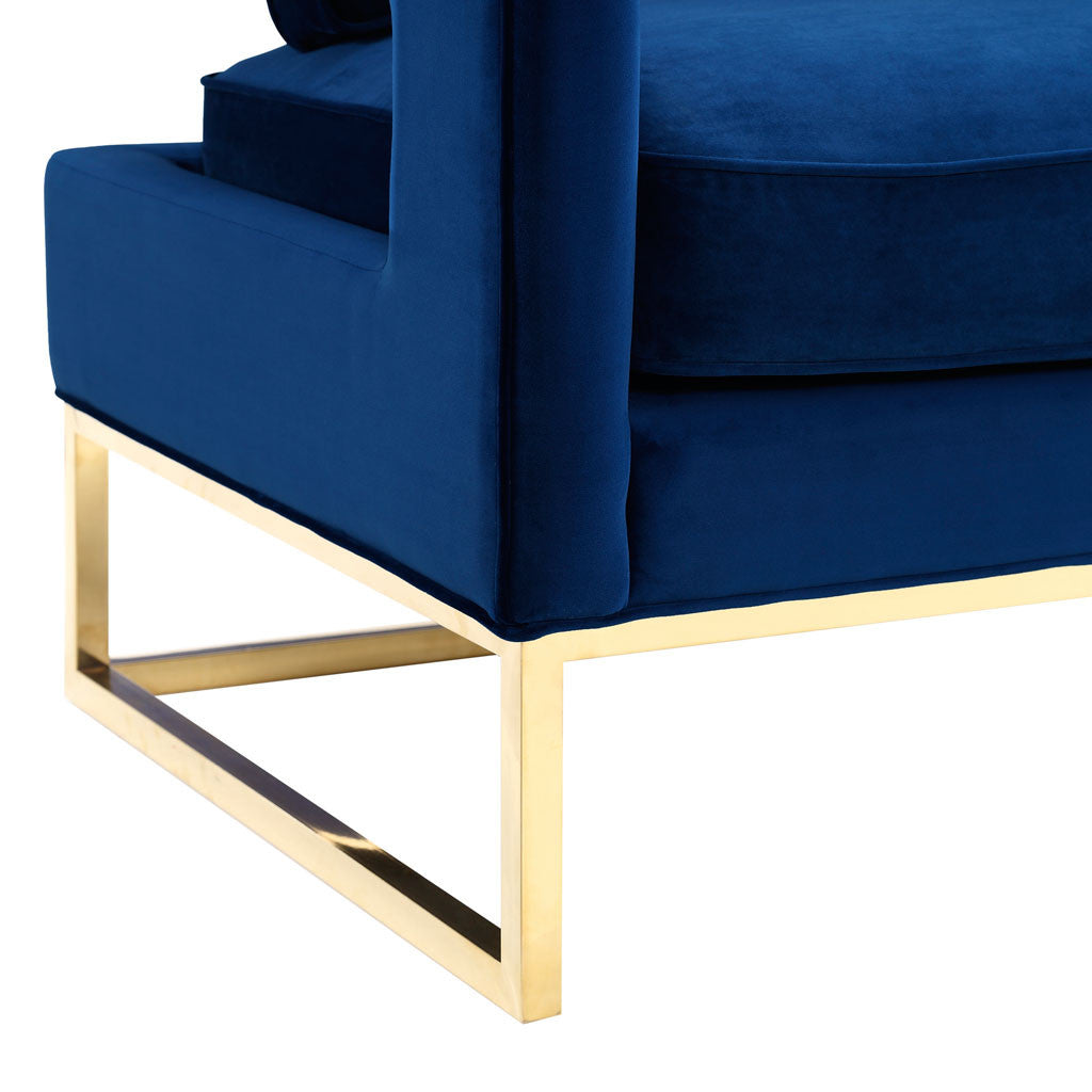 A geometric gold stainless steel base adds shine beneath the chair's soft navy velvet upholstery.