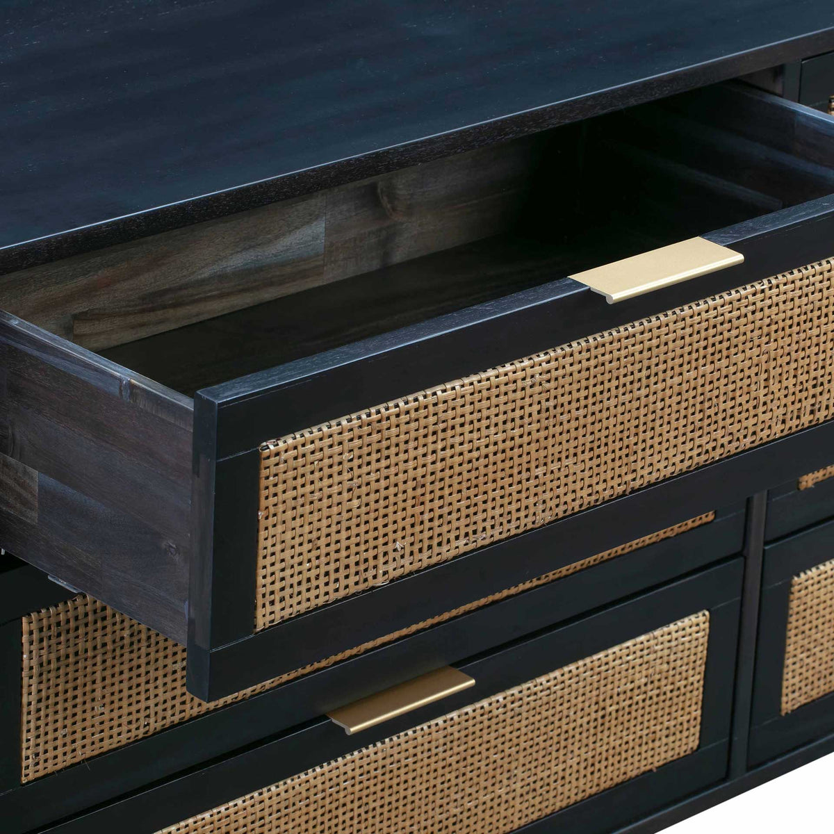 A wide upper drawer reveals a dark wood interior, natural cane panel, and slim brass-tone pull.
